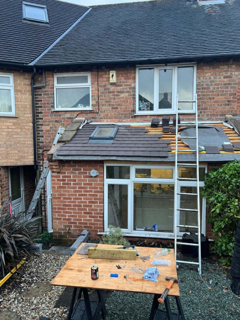 This is a photo of a roof extension that is having new roof tiles installed. This is a photo taken from the roof ridge looking down a tiled pitched roof on to a flat roof. Works carried out by LS Roofing Amersham