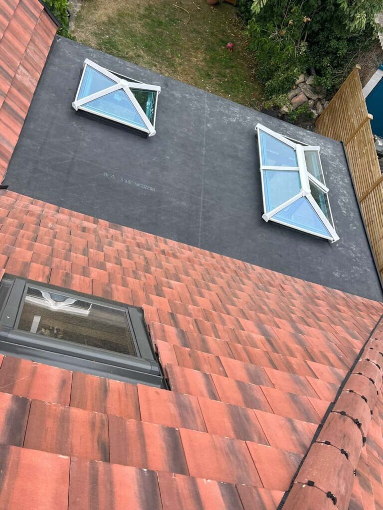 This is a photo taken from the roof ridge looking down a tiled pitched roof on to a flat roof. Works carried out by LS Roofing Amersham